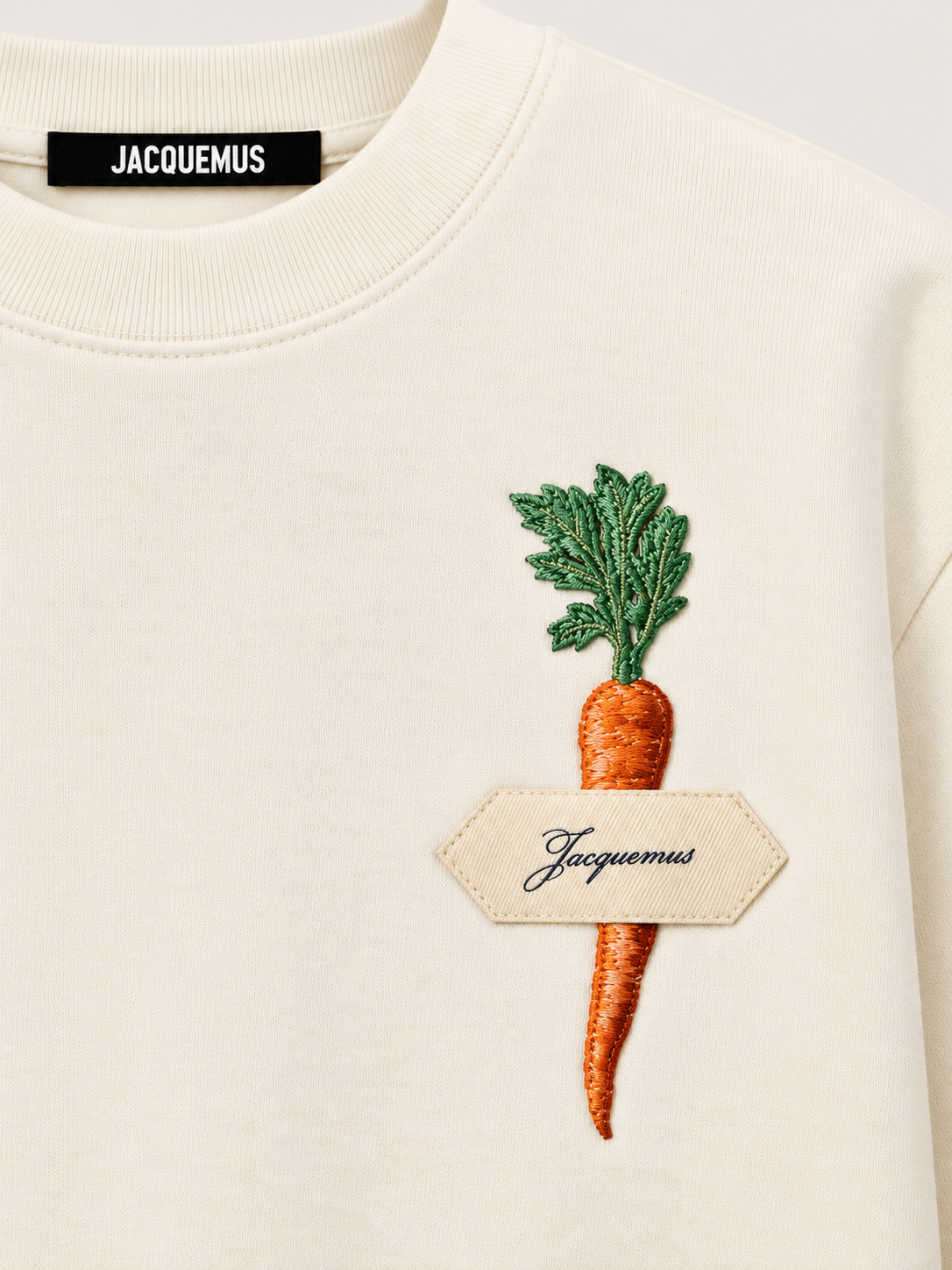 Dettaglio applicazione fragola con logo sulla T-shirt Jacquemus off white