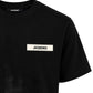 Dettaglio patch logo Jacquemus in gros-grain su T-shirt nera