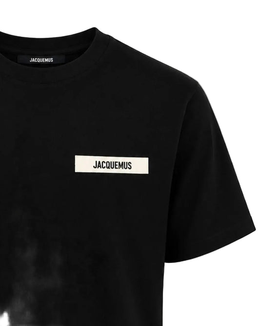 Dettaglio patch logo Jacquemus in gros-grain su T-shirt nera